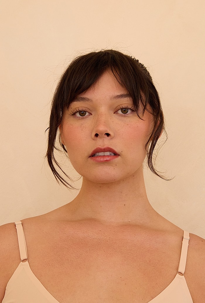Portrait of woman with light makeup and expression.