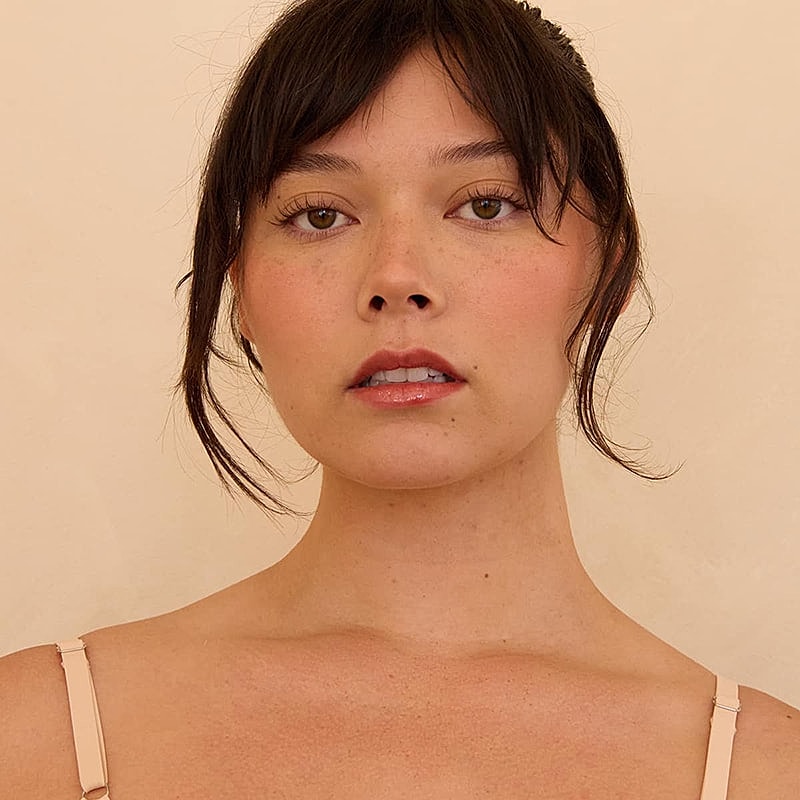 Woman with natural makeup and dark hair.