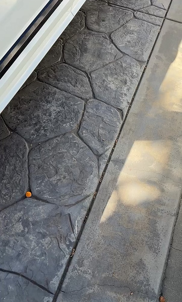 Textured concrete driveway with vehicle overhead.