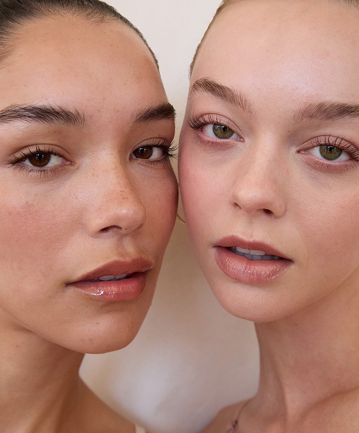 Two women posing closely, showcasing natural beauty.