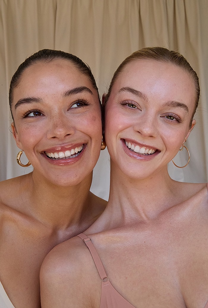 Two smiling women posing together.