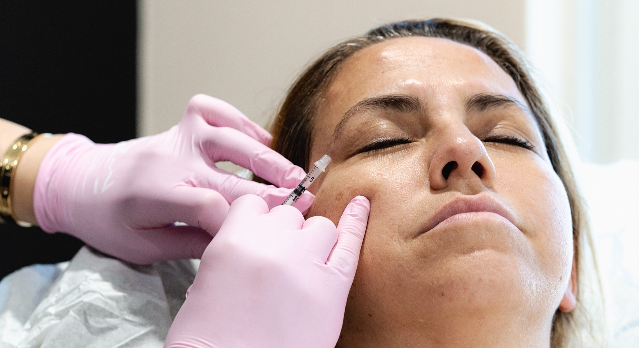Administering injectables in a facial treatment session.